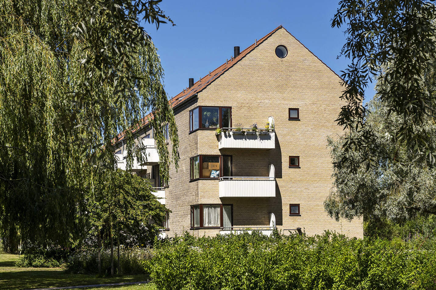 gul murstensbygning i grønt område